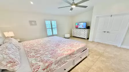 Master bedroom with TV and ceiling fans