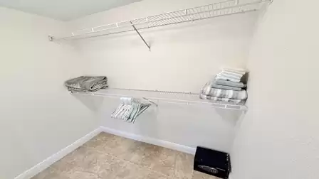 Walk-in closet with ample storage, shelving system and space for clothes and luggage.