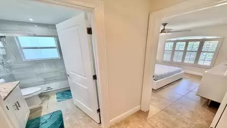 Hallway view with direct access to the modern bathroom and the bedroom.