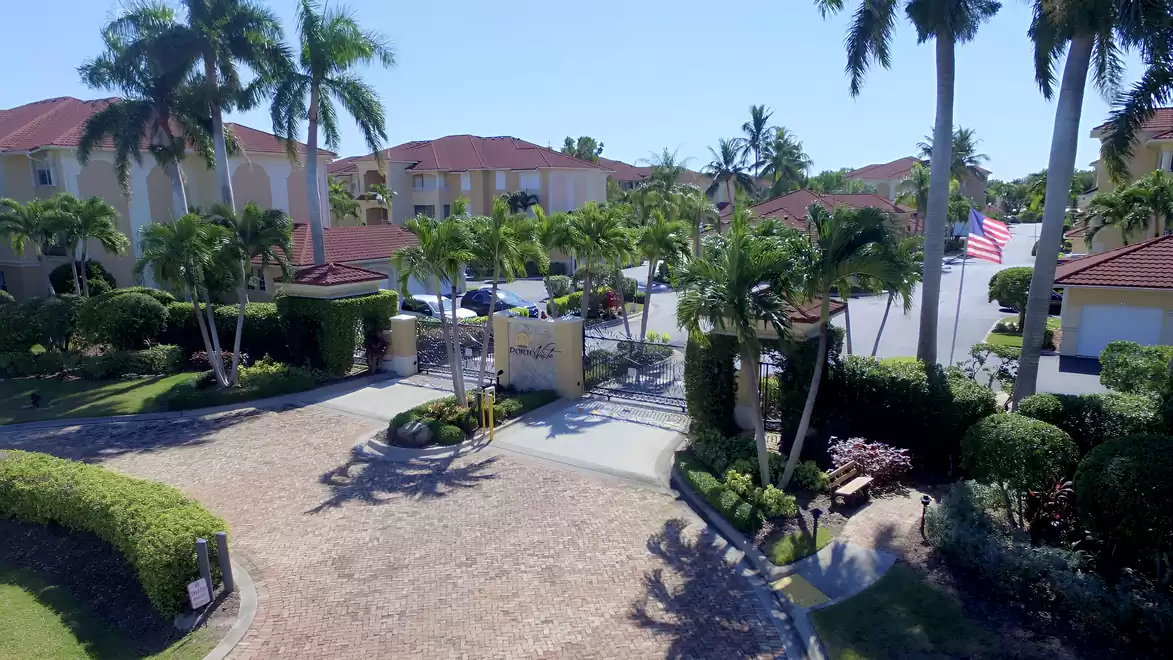 Gated entrance of the Porto Vista community with palm trees, entrance gate, and well-maintained tropical landscaping.