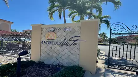 Gated entrance of the Porto Vista community with palm trees, logo and controlled access