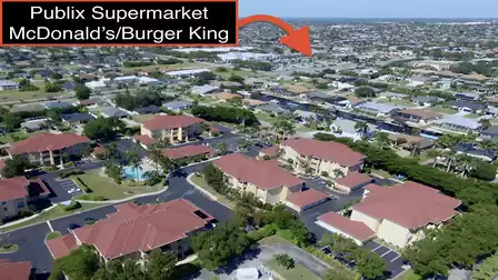 Aerial view of a residential community with pool, palm trees and close proximity to shops and restaurants