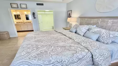 Bedroom with king-size bed, en-suite bathroom access, and walk-in closet, bright and relaxing.