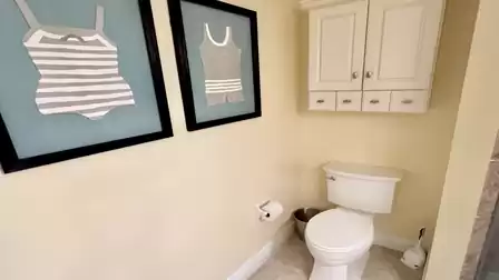 Separater WC-Bereich mit Toilette, Stauraumschrank und maritimer Wanddekoration