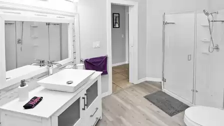 Modern pool bathroom/guest bathroom with floor-level shower and washing area, ideal for guests and bedrooms 2 and 3