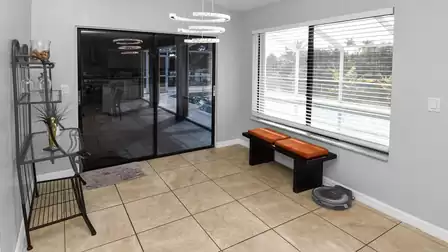 Bright transitional area with bench seat and direct access to the outdoor kitchen and pool 