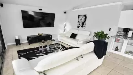 Modern living area with comfortable sofas, large TV and open connection to the kitchen