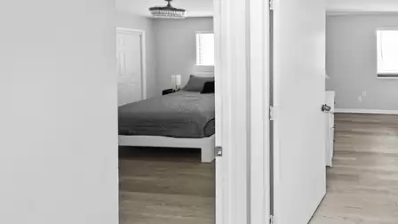 Hallway view leading to two bright bedrooms with a calm and private layout