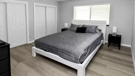 Modern bedroom with large double bed, ample storage and a calm, neutral design