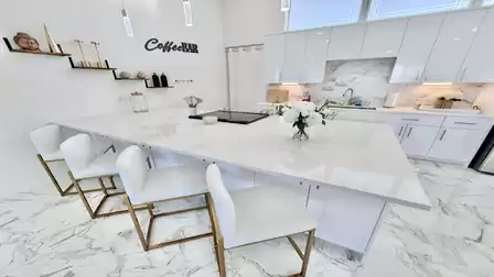 Modern kitchen with a spacious island, stylish bar stools, and premium finishes in an elegant design.