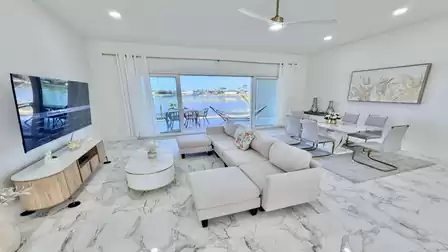 Bright living and dining area with lake views, large windows, and direct access to the waterfront terrace.