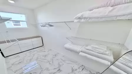 Walk-in closet with ample storage space, dresser, and practical amenities for a comfortable stay.