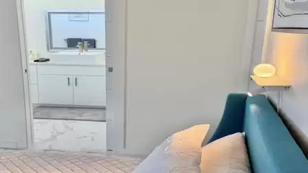 Modernes Schlafzimmer mit direktem Zugang zum stilvollen Badezimmer und hochwertiger, heller Ausstattung.