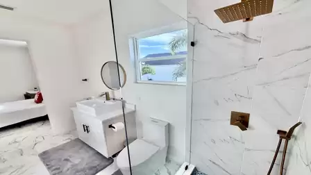 Modern bathroom with a rain shower, elegant vanity, and direct access to the comfortable bedroom.