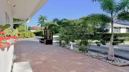 Covered entrance patio of the vacation villa in Fort Myers, surrounded by tropical plants and landscaped gardens.