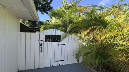 Private entrance to the outdoor area of the vacation villa in Fort Myers, surrounded by tropical plants and palm trees.