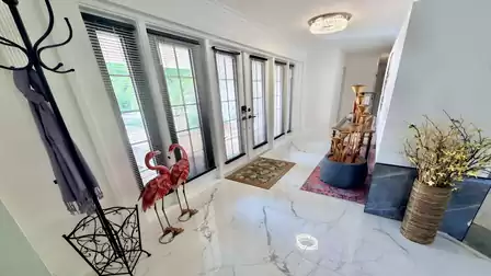 Elegant foyer of the vacation villa in Fort Myers featuring floor-to-ceiling windows, premium tile flooring and stylish décor.