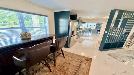 Open living area of the vacation villa in Fort Myers featuring a workspace, modern kitchen and bright open-concept design.