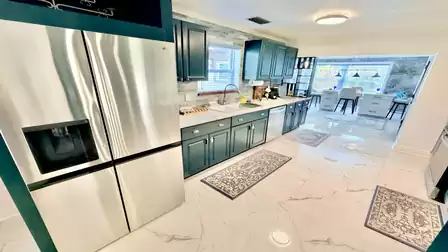 Modern kitchen in the vacation villa in Fort Myers featuring stainless steel appliances, ample counter space and an open dining area.