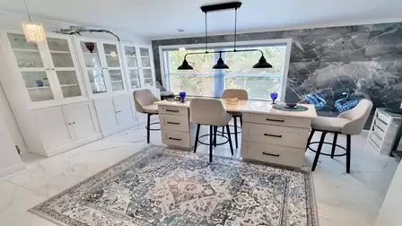 Bright dining area with a stylish kitchen island, comfortable bar stools, and large picture window - perfect for shared meals and relaxing gatherings.