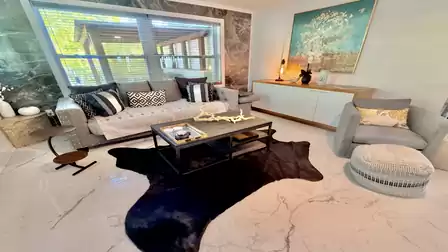Cozy living area with stylish seating, modern décor, and a large window that fills the space with natural light - the perfect place to relax and unwind during your vacation.