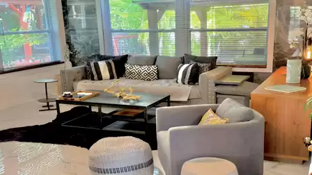 Inviting living area with a comfortable sofa, stylish armchairs, and large windows overlooking tropical greenery - perfect for relaxing and enjoying the bright, open atmosphere.