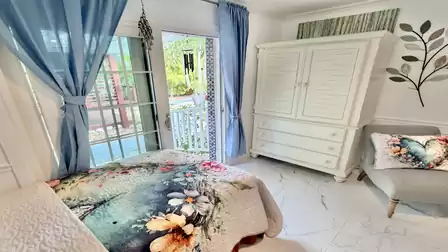 Bright guest bedroom with floral décor, direct patio access, and plenty of natural light