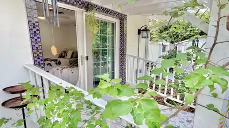 Covered patio entrance with sliding door, Mediterranean tiles, and lush garden views