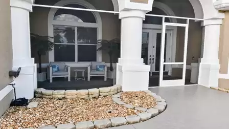 Villa Almare vacation rental Cape Coral front entrance with columns, screen door and stone landscaping