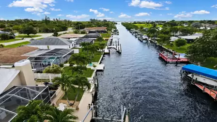 Aerial canal scene with residential docks, covered boat lifts and red side decks