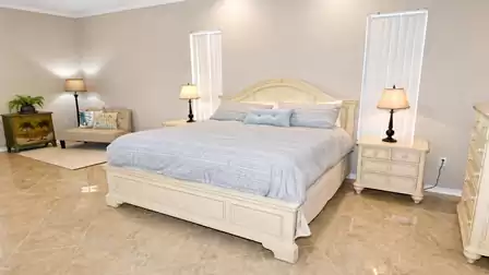 Bedroom with king-size bed, two nightstands, corner bench and tropical cabinet
