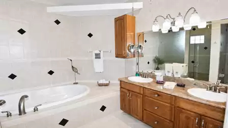Bathroom with corner bathtub, double vanity, wall-mounted towel rail and large mirror