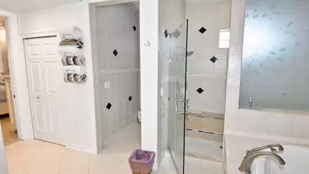 Bathroom with walk-in shower, frosted window, towel rack and doorway back to bedroom