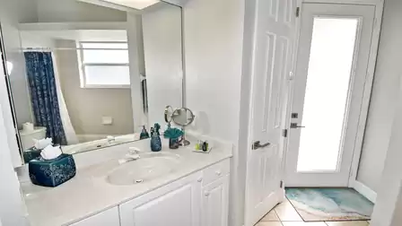 The second bathroom functions as a pool bathroom and has a bathtub with shower