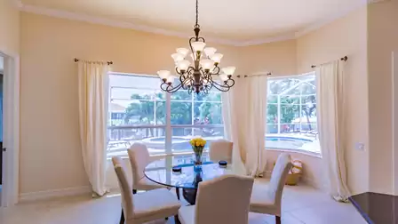 The cozy dining area overlooks the pool area and canal