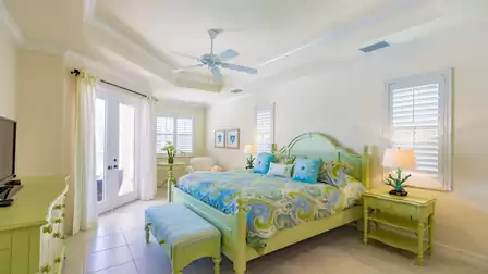 Contemporary beach-style furnishing are featured in the master bedroom