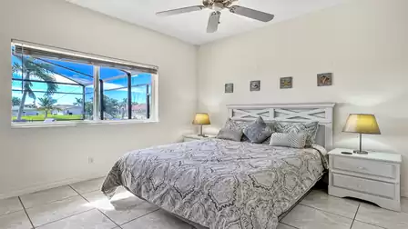 White cottage style furnished bedroom with queen bed