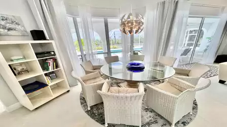 Modern dining area with views over the pool and the canal
