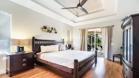 The stylish master bedroom offers a King size bed and access to the pool area