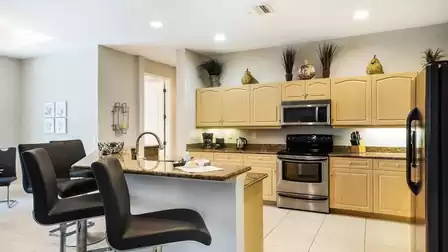 The kitchen with the long breakfast bar is fully equipped