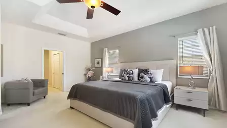 Large master bedroom with separate armchair for reading.