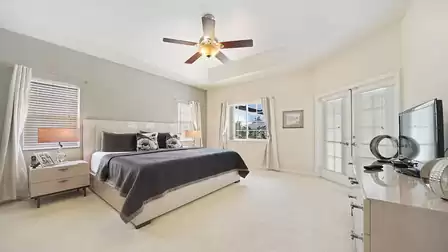 French doors lead from the spacious master bedroom to the pool area