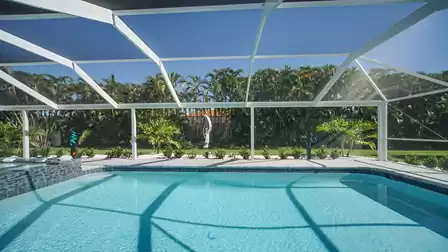 The entire pool area is surrounded by lush tropical landscaping