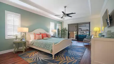 The stylishly furnished master bedroom offers access to the pool area