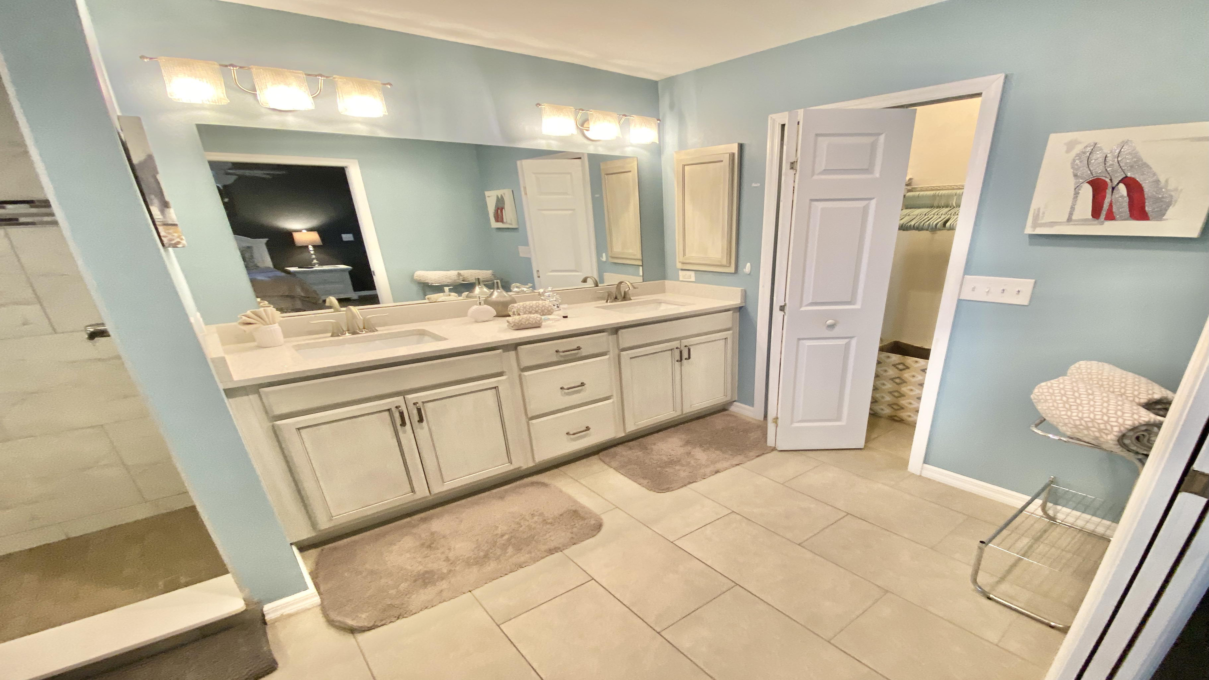 The adjacent master bath features double sinks and a shower