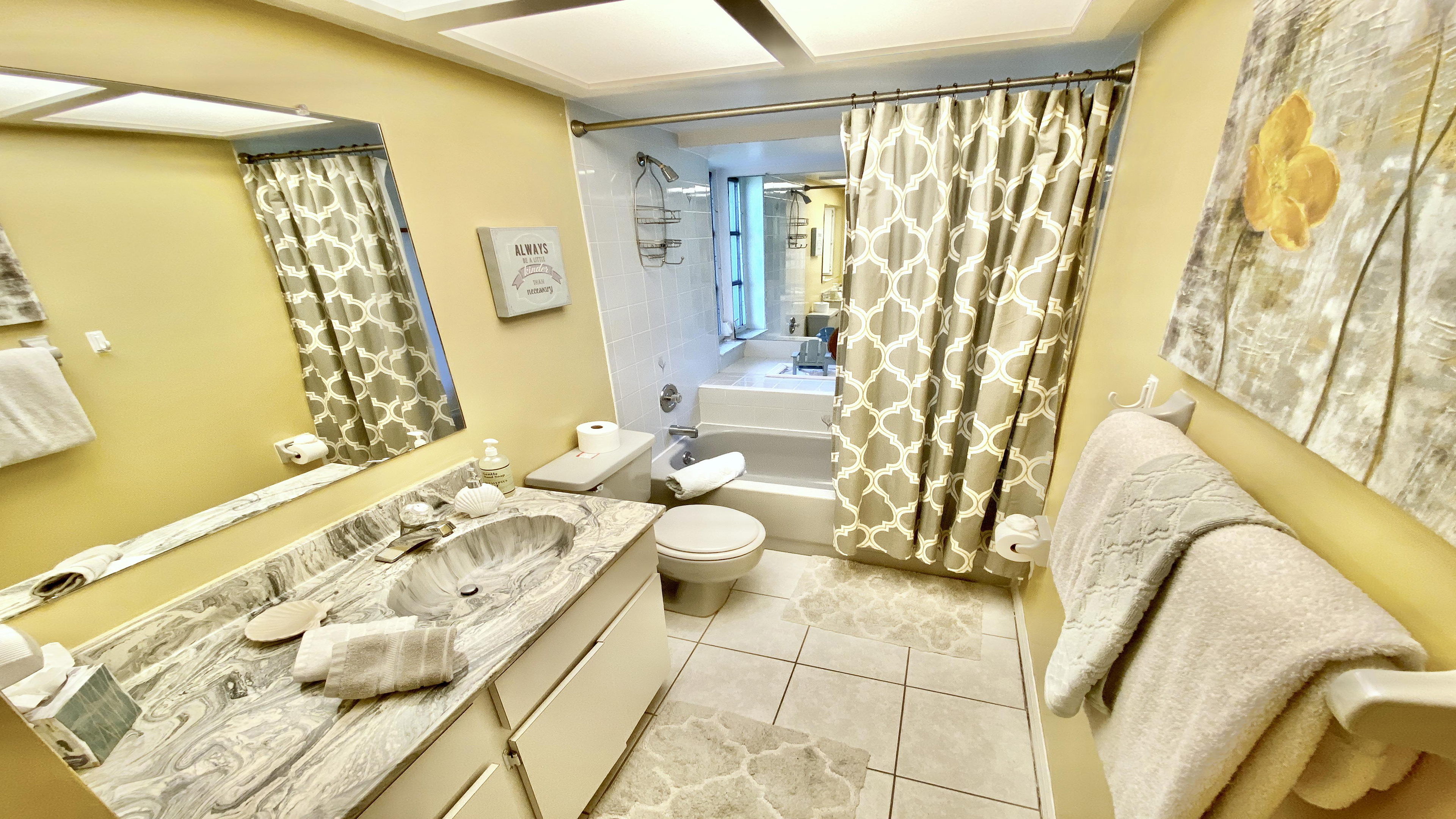 The yellow bathroom with bathtub shower,sink and toilet