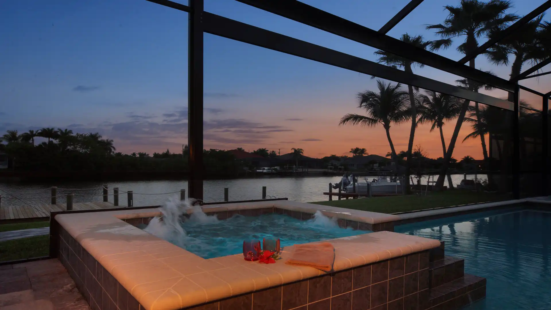 Illuminated spa of Villa Elvenar with romantic view of the waterway at sunset.