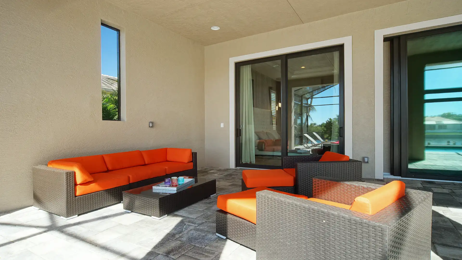 Cozy lounge area with modern rattan furniture and orange cushions on the terrace.