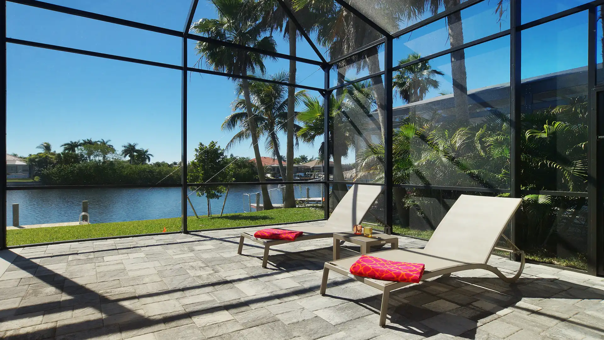 Private sunbathing area with comfortable loungers and a tropical view of palm trees and the canal.