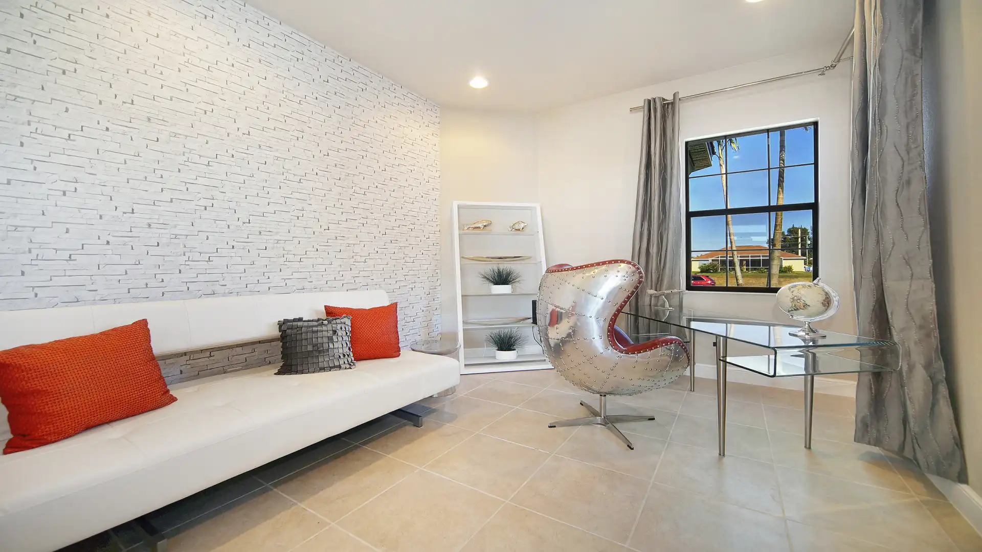 Bright office with a designer chair, glass desk, and decorative wall design.
